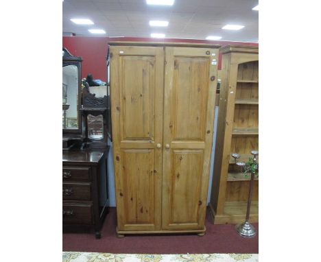 A Pine Twi Door Wardrobe, with single internal shelf and rail, raised on bun feet, 180cm high.