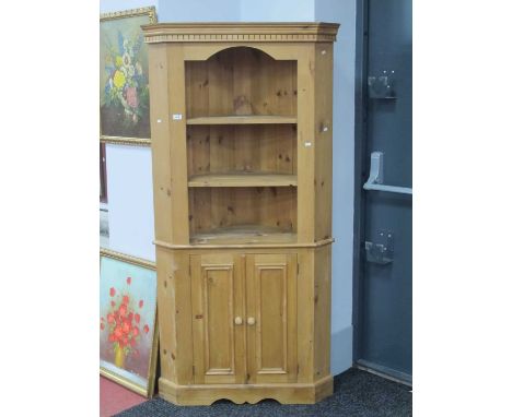 A Pine Floor Standing Corner Cupboard, the top with two open shelves, the base with doors enclosing single shelf, 183cm high.