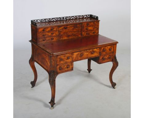 A Victorian walnut desk, the upright back with pierced three quarter gallery above a central sliding panel enclosing pigeon h