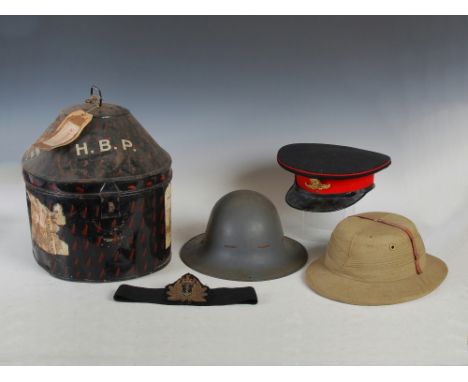 An early 20th century Royal Artillery Officers dress hat, a Pith hat, an A.R.P helmet and a Japanned metal hat box bearing in