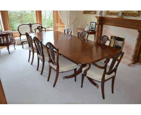 A George III style mahogany twin pedestal dining table and eight George III style dining chairs, the twin pedestal table encl