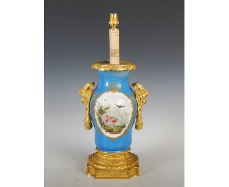 A late 19th/ early 20th century Continental porcelain blue ground ormolu mounted table lamp, decorated with oval-shaped panel