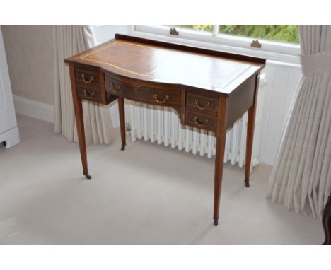 An Edwardian mahogany and chequer banded writing desk, the rectangular top with brown leather insert and gilt tooled border, 