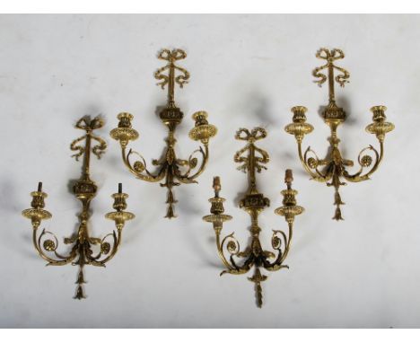 A set of four Neo-Classical style gilt metal two light wall sconces, the urn shaped lights supported on scroll and foliate ca