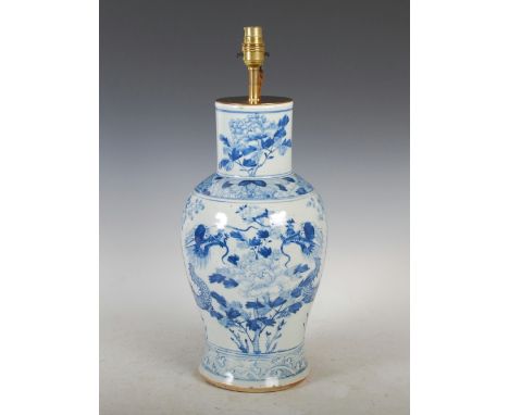 A Chinese porcelain blue and white vase, Qing Dynasty, decorated with two dragons and peony within diaper borders, converted 