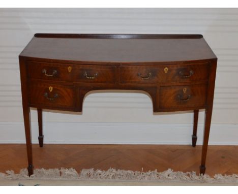 A 19th century mahogany and boxwood lined bow front knee hole dressing table, the shaped rectangular top above two frieze dra