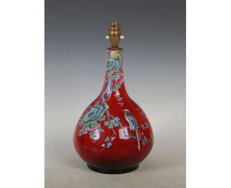 A Chinese porcelain sang-de-boeuf glazed bottle vase, Qing Dynasty, decorated in coloured enamels with a magpie perching on a