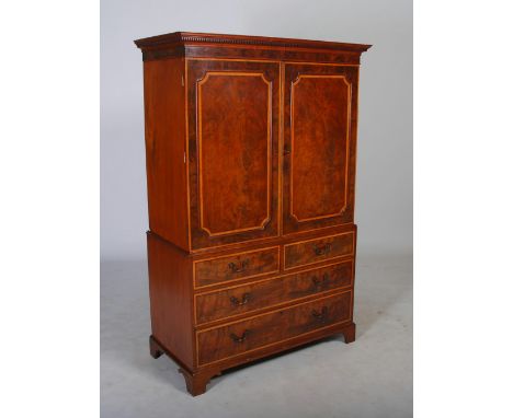 A 19th century mahogany and satinwood banded linen press, the moulded cornice and dentil frieze above a pair of panelled cupb