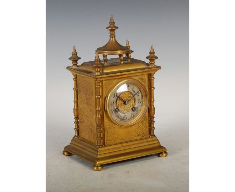 A late Victorian gilt metal mantle clock, the circular dial with Arabic numerals and pierced fret work centre, the twin train