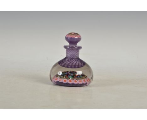 A Monart glass millefiori inkwell and stopper, decorated with colourful millefiori canes on a purple ground, the inkwell rese