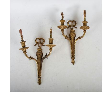 A pair of late 19th/ early 20th century ormolu two light wall sconces in the Neo-Classical style, with ribbon tie surmounts, 