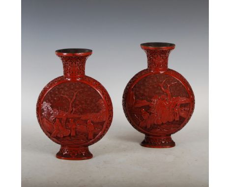 A pair of Chinese cinnabar lacquer pilgrim vases, Qing Dynasty, carved with circular panels of scholars, rockwork, pine and o