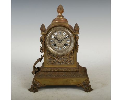 A late 19th century French gilt metal mantle clock, the silvered dial with enamelled Roman numeral panels and twin train move