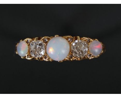 A Victorian opal and diamond ring, set with three round cabochon opals, estimated to weigh 0.750ct, and two cushion cut diamo