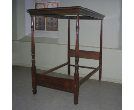 A late 19th century mahogany four poster single bed, the canopy with a moulded edge and dentil frieze, raised on tapered squa