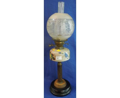 Brass double burner oil lamp with floral painted ceramic reservoir on pedestal base, having etched shade and clear chimney.