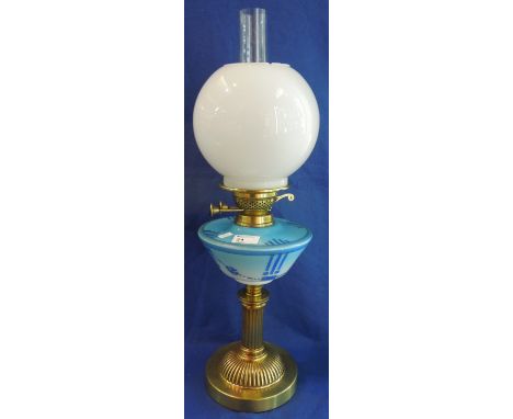 Brass double burner oil lamp with painted ceramic reservoir and brass fluted, column base, having opaque glass shade and clea