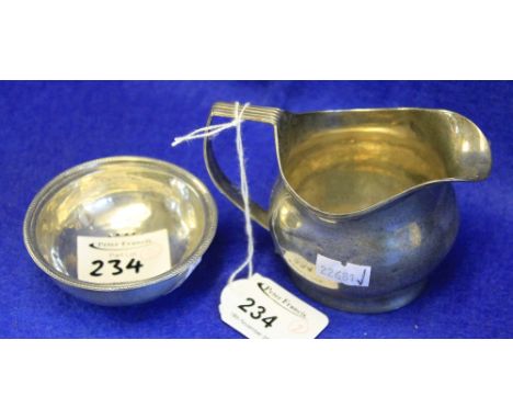 Silver helmet shaped cream jug together with silver circular strainer. (2)