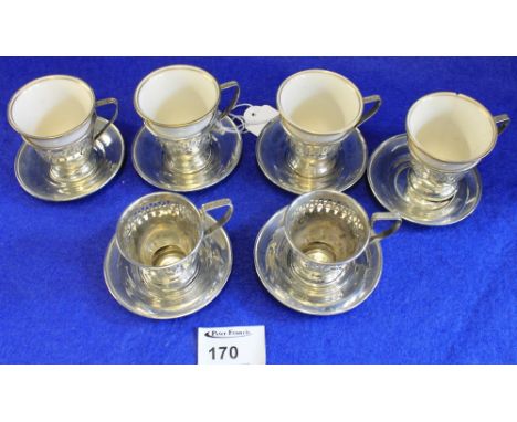 Four ceramic coffee bowls together with sterling silver pierced holders and saucers.