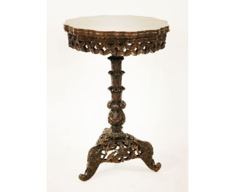 An Anglo-Indian rosewood lamp table, the shaped circular top over a profusely pierced and cased apron, column and triform sta