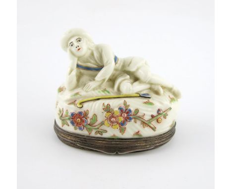 A Mennecy porcelain silver-mounted snuff box and cover, c.1740, modelled as a reclining shepherd, leaning his head on his rig