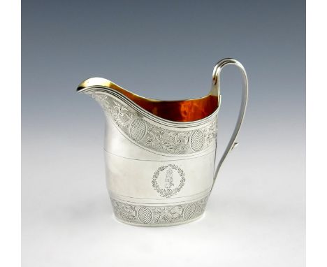 A George III silver cream jug, by Henry Chawner, London 1794, oval form, scroll handle, gilded bowl, engraved foliate decorat