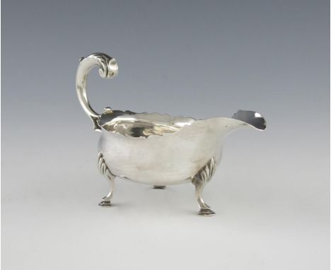 A George III silver cream / small sauce boat, by Hester Bateman, London 1779, oval form, wavy-edge border, leaf capped scroll