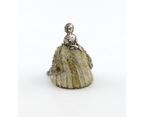 A silver pin cushion, by Saunders and Shepherd, Birmingham 1921, modelled as a lady, the top half of her body in silver, the 