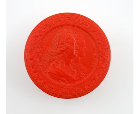 λA 19th century red lacquered snuff box, circular form, the pull-off cover with a raised relief of the bust of Louis XIV and 