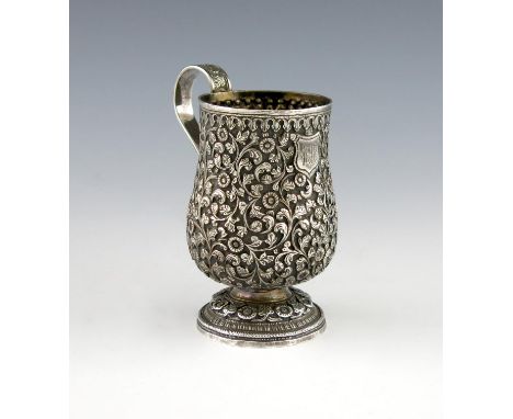 A late-19th century Indian silver mug, unmarked, circa 1880. baluster form, chased foliate scroll decoration on a matted back