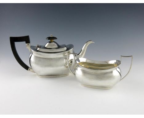 A silver teapot and sugar bowl, by The Barker Brothers Ltd., Birmingham 1928, oblong bellied form, scroll handles, length han