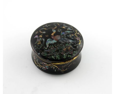 λAn 18th century black lacquered tortoiseshell snuff box, circular form, the hinged cover with birds and vegetation inlaid wi