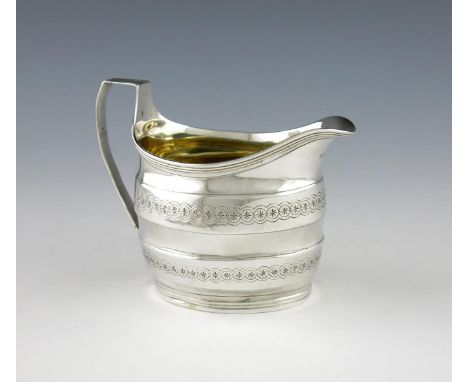 A George III silver cream jug, by David and Robert Hennell, London 1898, oval form, engraved decoration, scroll handle, gilde