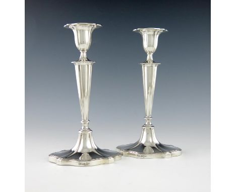 A pair of silver candlesticks, by Walker and Hall, Sheffield 1912, shaped oval tapering form, reeded borders, height 24cm. (2