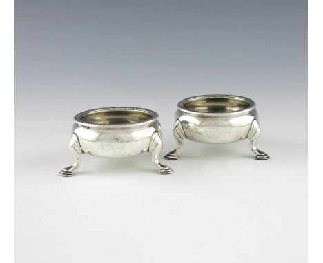 A pair of George II silver salt cellars, by Edward Wood, London 1742, plain cauldron form, rope-work border, on three hoof fe