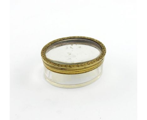 A 19th century French gold-mounted glass snuff box, circa 1830, oval form, foliate borders, hinged cover, length 6.4cm.