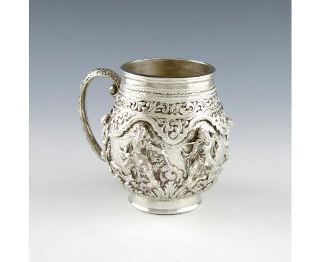 A late 19th century Indian silver mug, unmarked, circa `890, circular bellied form, heavily embossed with figures and chased 