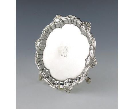 A George II silver waiter, by William Peaston, London 1751, circular form, foliate scroll border, the centre with a crest, on