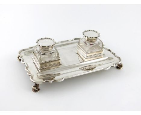 A silver inkstand, by Charles Stuart Harris, London 1915, rectangular form, wavy-edge border, with two pen wells, and with tw