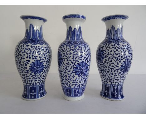 Near pair of Chinese porcelain baluster vases with underglaze blue decoration of flowerheads, on a scrolling foliate ground, 