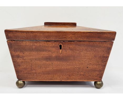 19th century mahogany sarcophagus-shaped tea caddy, the hinged top opening to reveal compartmented interior, the whole raised