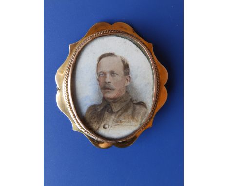 An oval 9ct brooch set with an overpainted photographic portrait of a soldier, 2.2”