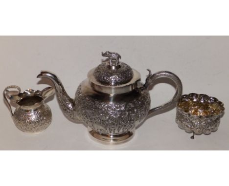 An Eastern metal teapot embossed elephants and lions and with elephant finial, 9.5” a half-fluted sugar basin decorated anima