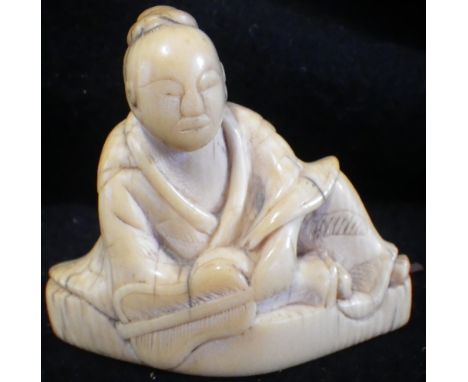 A JAPANESE CARVED IVORY NETSUKE, EDO PERIOD, EARLY 19TH CENTURY, modelled as a seated figure holding a feather fan, 5.5cm hig