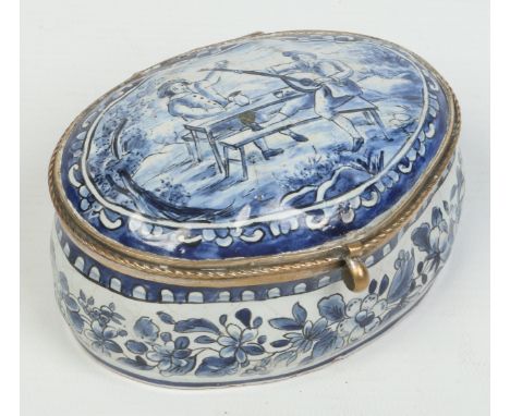 A Continental blue and white delft oval trinket box with hinged cover. Painted with a pair of revelers and floral borders. Pf