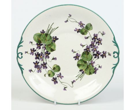 A Wemyss bread and butter plate. Edged in green enamel and decorated with purple flowers. Impressed and painted mark, 25cm wi