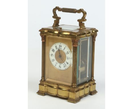 A 19th century French brass cased carriage clock. With serpentine formed case having Corinthian column supports with copper t
