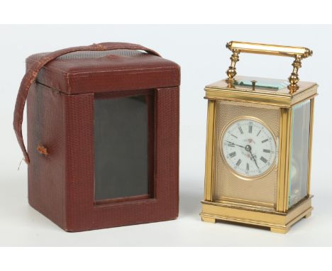 An early 20th century French brass carriage clock in fitted case. With engine turned mask, enamel dial decorated with flowers