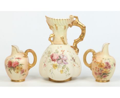 A Royal Worcester blush ware ewer with gilt coral moulded handle and two flat back jugs with gilt reeded loop handles. Each d
