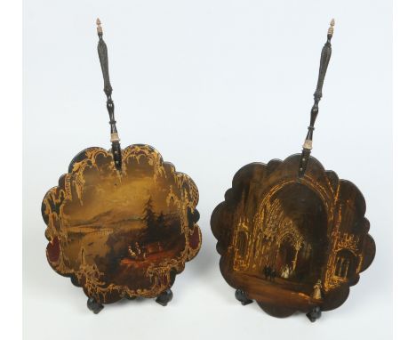 A matched pair of Victorian lacquered papier mache face screens. With turned and carved handles, each fluted panel painted an
